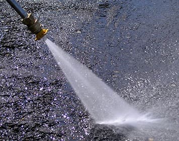 High-pressure power washing of pavement
